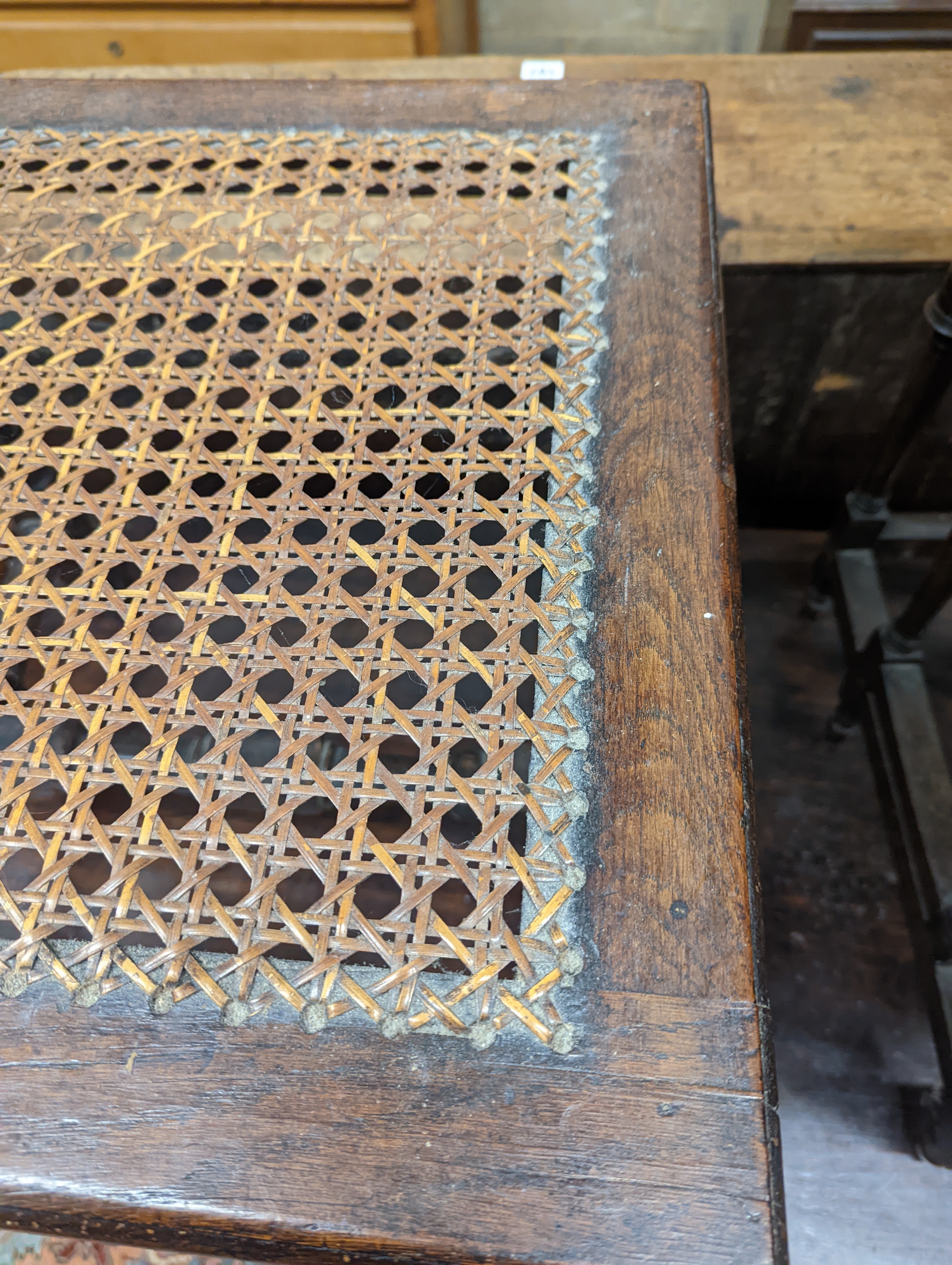 A 17th century style carved oak stool, with caned seat and H stretcher, width 47cm, depth 46cm, height 42cm